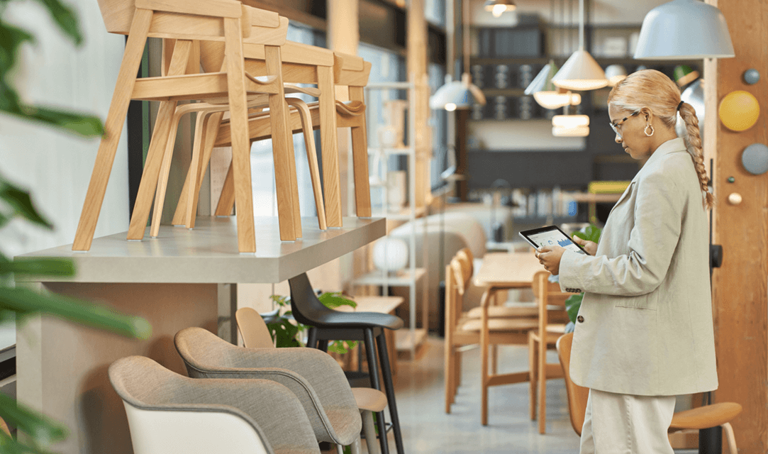 A female store owner in her furniture shop examining inventory on her tablet mobile Access Database app