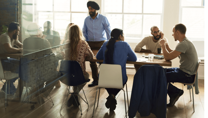 Developers seated around a table participating in the Microsoft 365 developer community