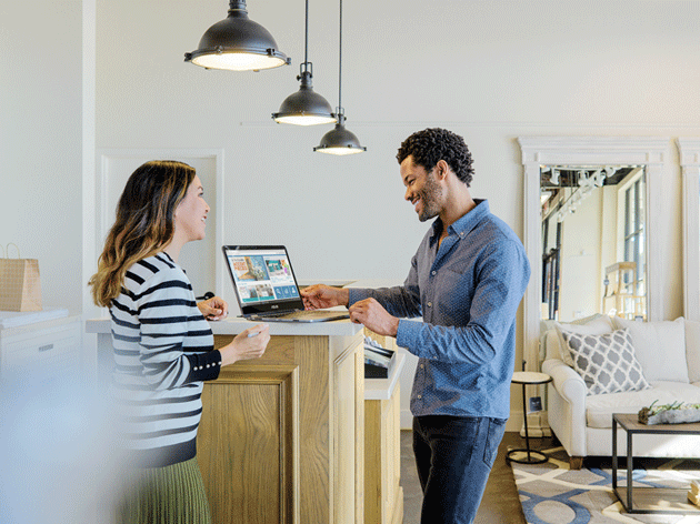 Man and woman talking over a laptop