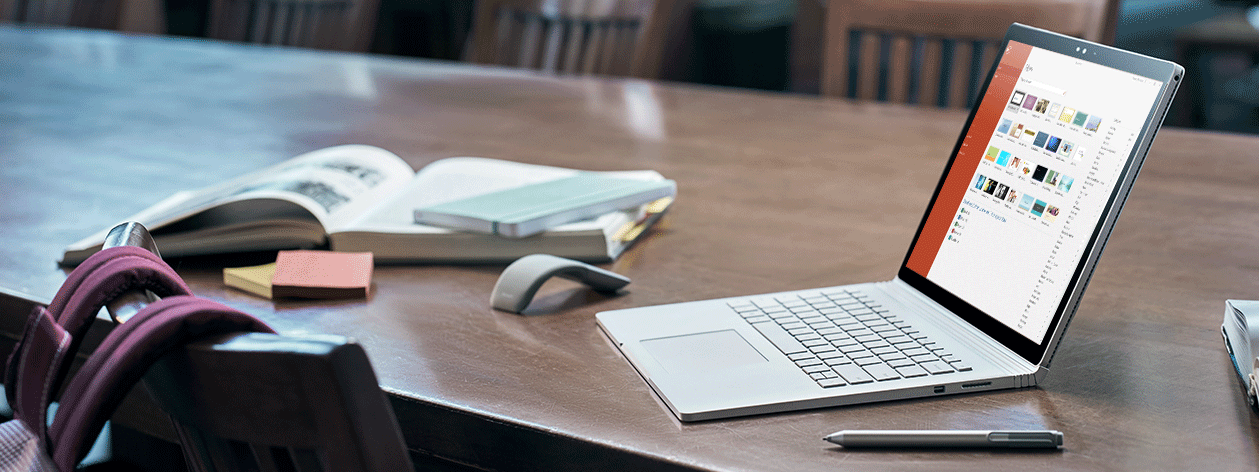 Ноутбук на столе, на котором отображается экран открытия файла PowerPoint